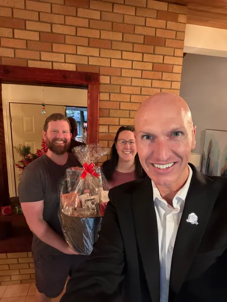 Kyle delivering a gift basket to new homeowners