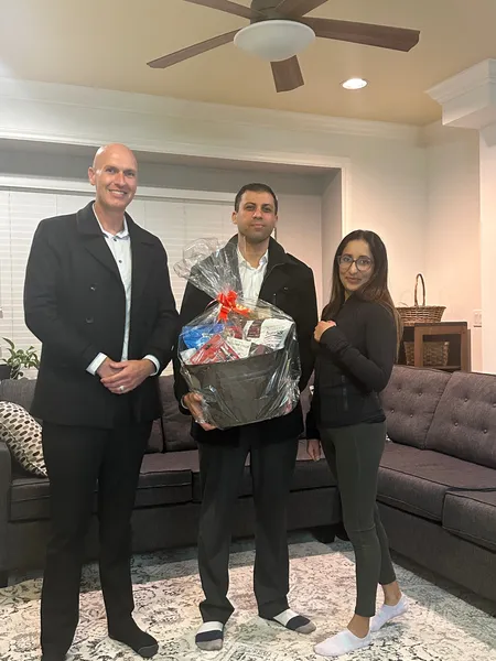 Kyle with clients receiving a gift basket