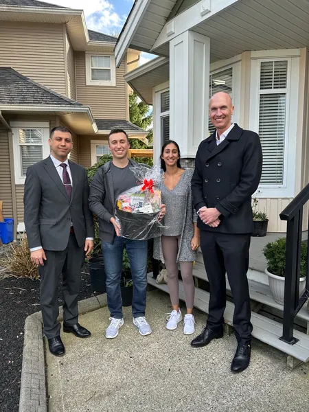 Kyle with new homeowners on their front porch